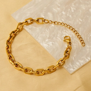 Bracelet chaîne à maillons fer à cheval dorés avec fermoir mousqueton sur marbre