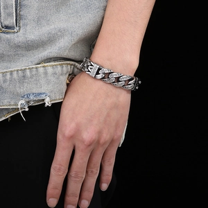 Close-up of men's vintage silver heavy chain bracelet with engraved texture on wrist