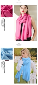 Detail of pink and sky blue linen scarves showing soft fabric texture and fine tassels