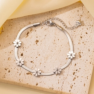Detalle de pulsera de cadena plana plateada con cinco flores mates sobre piedra natural