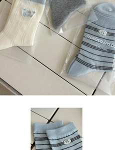 Detail of cream and blue cotton crew socks with embroidered bear and Bonjour lettering