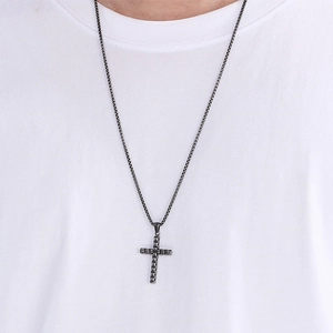 Détail d'un pendentif croix en acier inoxydable noir avec chaîne box porté par un mannequin