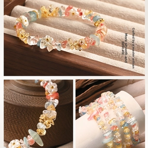 Macro shot of colorful natural crystal stone bracelet with white flower charms on a stand