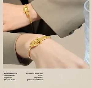 Détail du bracelet en acier titane plaqué or 18 carats avec boucle porté au poignet