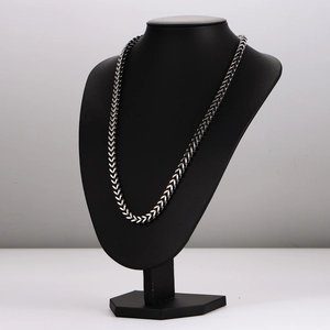 Silver cuban chain necklace with heavy wheat weave design on a black mannequin display