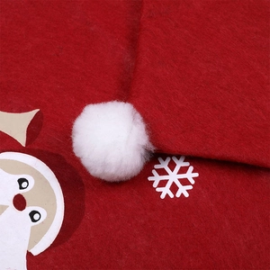 Detailed macro view of red Christmas chair cover with white snowflake and plush pom-pom