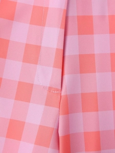 Detailed macro view of pink and orange checkered fabric texture with clean stitching lines