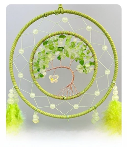 Detailed view of handmade Tree of Life dream catcher with green crystals and soft feathers