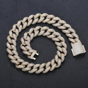 Macro shot of 18mm gold Cuban link necklace with micro-pave zircons on black surface