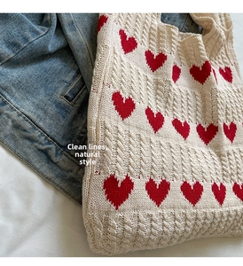 Detalle de bolso de punto con estampado de corazón rojo y textura de punto grueso