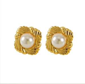 Detailed close-up of vintage 18K gold shell-shaped pearl stud earrings with wavy texture