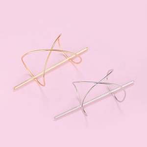 Irregular geometric metal hair stick in gold and silver finish on pink background