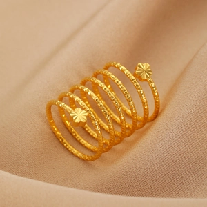 Detailaufnahme eines goldenen Spiralrings mit Hammerschlag-Textur und 3D-Blüten