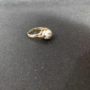 Macro shot of handmade wire-wrapped open ring with a round spotted marble stone
