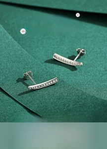 Macro detail of S925 sterling silver curved earrings with shimmering cubic zirconia