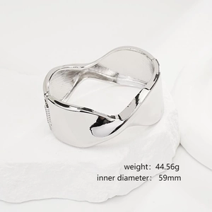 Close-up of polished silver wavy wide cuff bracelet with weight and size details