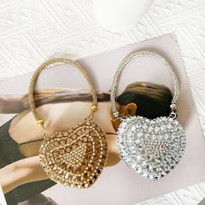 Detail of mini heart-shaped evening bags in gold and silver with shimmering rhinestones