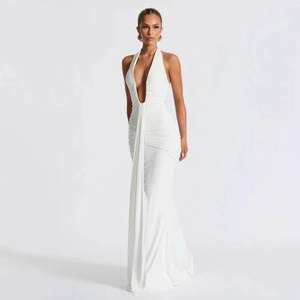 Detail of white deep V-neck halter dress featuring elegant ruching and long draped sash
