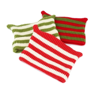 Detailed view of textured knit hats with cat ears in red, green, and white stripes