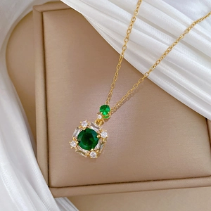 Luxurious gold necklace with emerald square pendant surrounded by small white crystals