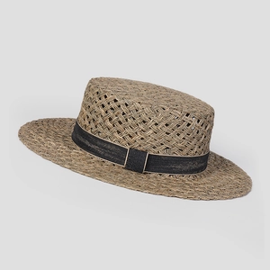 Close-up of hand-woven straw boater hat featuring a flat top and black grosgrain ribbon