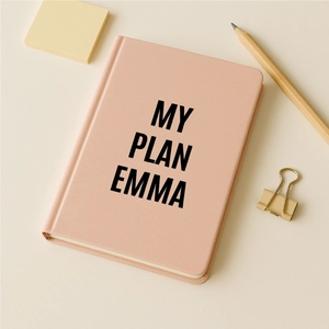 Close-up of pink matte leather planner featuring bold black MY PLAN EMMA lettering
