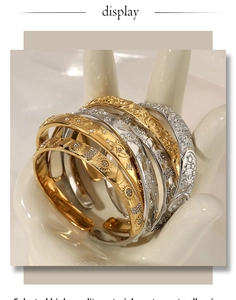 Detail of vintage sun and moon embossed stainless steel open cuff with tiny zircons
