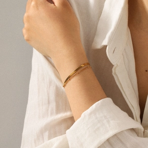 Close-up of a double-layered 18k gold plated stainless steel snake and bead bracelet