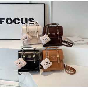 Close-up of vintage faux leather backpacks in multiple colors with star plush charms