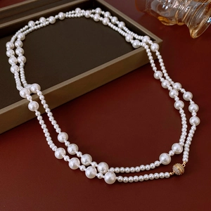 Détail d'un collier de perles double épaisseur avec fermoir magnétique doré et zircon