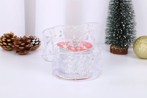 Detail of silver snowflake organza ribbon roll with festive Christmas decorations