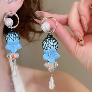 Detail of elegant drop earrings featuring blue flowers, mesh beads and pearl pendants
