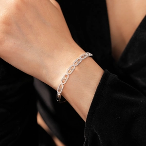 Close-up of silver-tone link bracelet with micro-pave zircons on black velvet sleeve