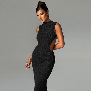 Detail of black slim-fit maxi dress featuring textured fabric and waist cutout detail