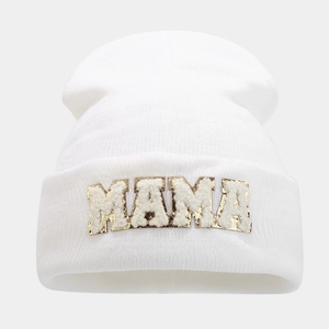 Detailed view of white knitted beanie featuring MAMA towel embroidery with gold sequins