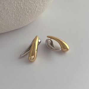 Close-up of elegant teardrop earrings with dual-tone gold and silver metallic finish