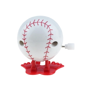Funny wind-up walking baseball toy with red mechanical feet on white background