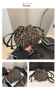 Detail view of leopard print bucket bag with black drawstrings and metal corners