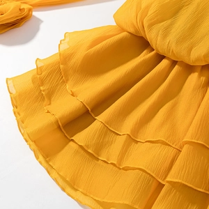 Detailed close-up of yellow chiffon tiered ruffle layers with pleated texture