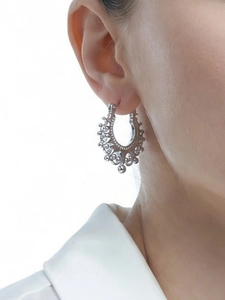 Macro shot of vintage U-shaped silver crown earrings with intricate bohemian engraving