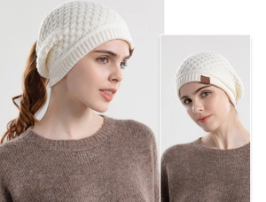 Detailed knit texture of a white winter beanie featuring a practical ponytail hole design