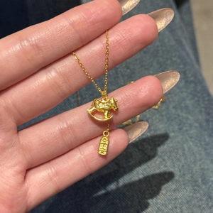 Detailed close-up of 24K gold plated rocking horse pendant with genuine gold hallmark tag