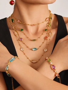 Détail du collier plaqué or 18 carats avec pierres en verre colorées et chaînes superposées