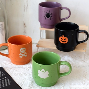 Set of four colorful Halloween ceramic mugs with skull spider pumpkin and ghost designs