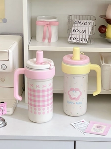 Detail of insulated tumblers with straws, cute patterns, and ergonomic handles
