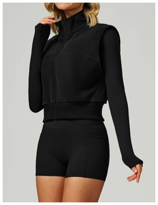 Détail de la veste de sport en polaire noire avec col montant et ourlet côtelé