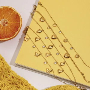 Detail of 18K gold plated stainless steel heart and butterfly charm bracelets