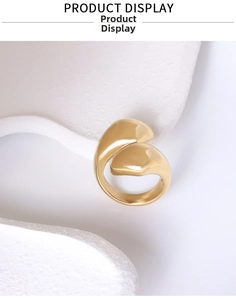 Detailed view of abstract gold water drop ring on white stone with polished finish