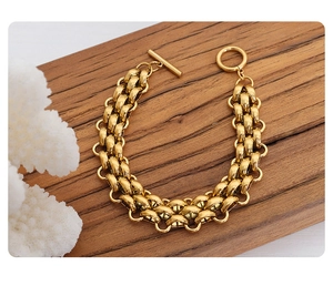 Detail of gold-plated thick chain bracelet with a T-bar toggle clasp and interlocking rings