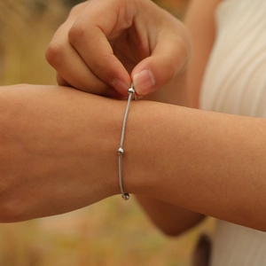 Close-up of a silver stainless steel ball bead bracelet on a woman's wrist